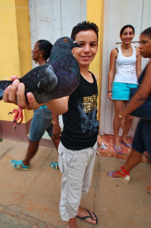 Cuba, Trinidad, chico mostrandouna paloma cazada